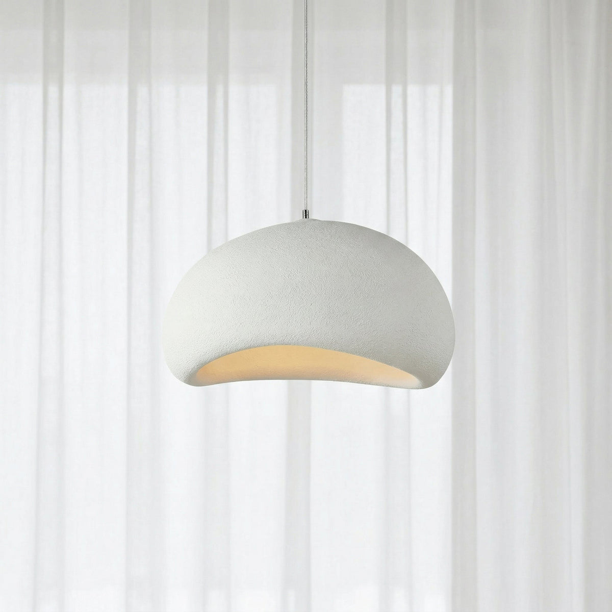 Suspension blanche au design arrondi devant une fenêtre